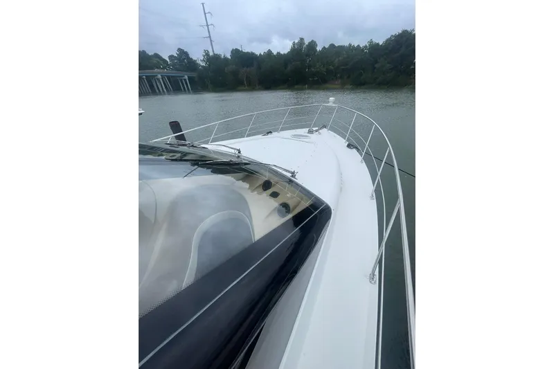 Sea Spirit Yacht Photos Pics 2004 Carver 570 Voyager Pilothouse yacht on a calm river, surrounded by trees.