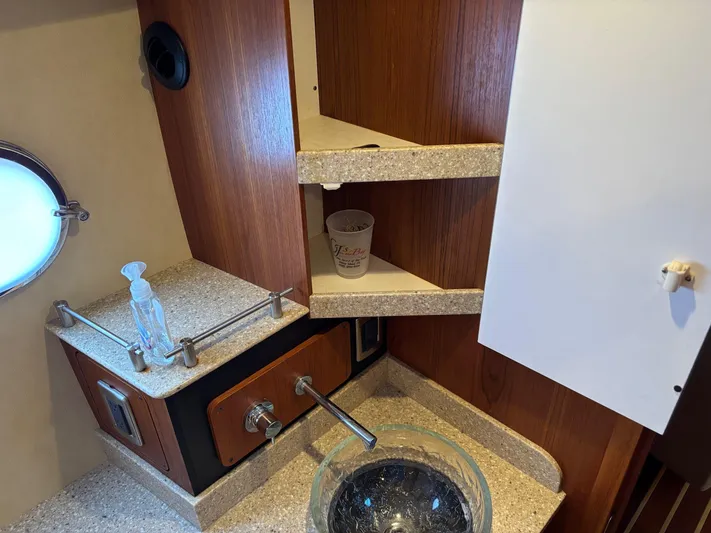 Cruise Prop Too Yacht Photos Pics 2010 Tiara Yachts 3900 Sovran bathroom with sink, shelves, and porthole window.