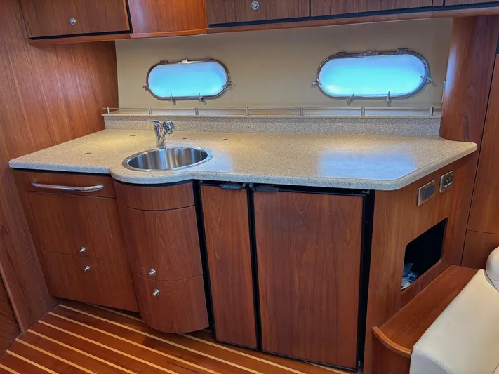 Cruise Prop Too Yacht Photos Pics 2010 Tiara Yachts 3900 Sovran kitchen with wood cabinetry and porthole windows.
