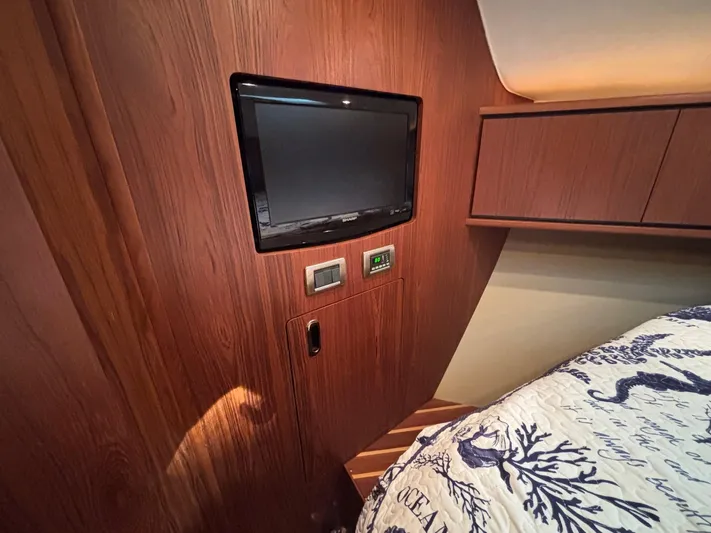 Cruise Prop Too Yacht Photos Pics 2010 Tiara Yachts 3900 Sovran cabin interior with TV and wooden paneling.