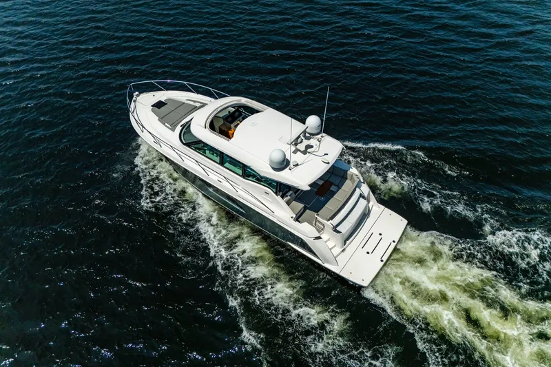  Yacht Photos Pics 2019 Tiara Yachts C49 Coupe cruising on open water, aerial view.