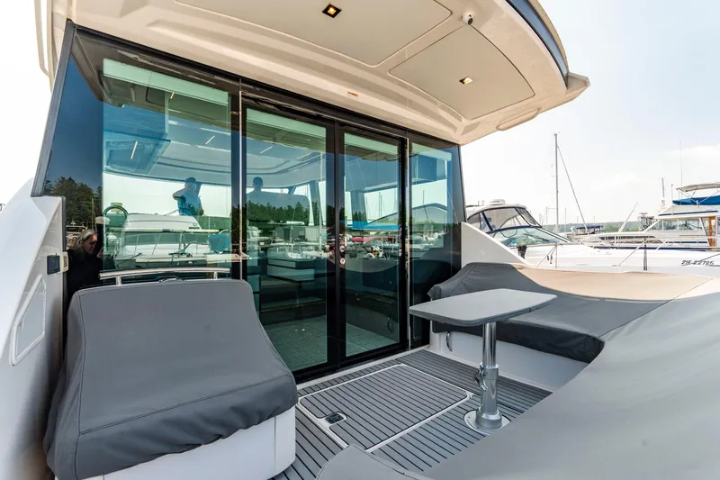  Yacht Photos Pics 2019 Tiara Yachts C49 Coupe deck with seating and table, docked at marina.