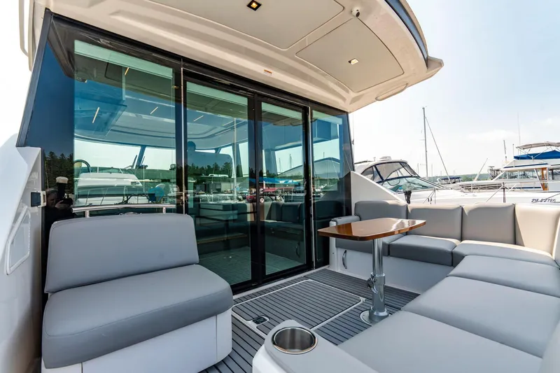  Yacht Photos Pics 2019 Tiara Yachts C49 Coupe, luxurious outdoor seating area with sleek design and marina view.