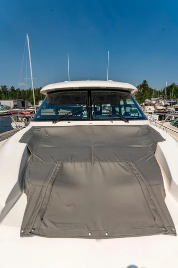  Yacht Photos Pics 2019 Tiara Yachts C49 Coupe with sunshade, docked at marina under clear blue sky.