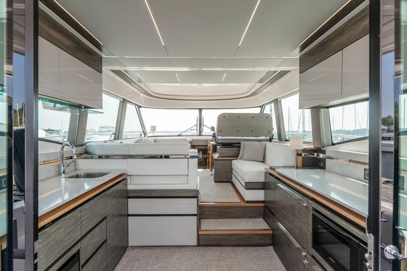  Yacht Photos Pics Luxurious interior of 2019 Tiara Yachts C49 Coupe with modern kitchen and seating area.