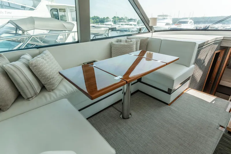  Yacht Photos Pics Luxurious interior of 2019 Tiara Yachts C49 Coupe with elegant seating and wooden table.