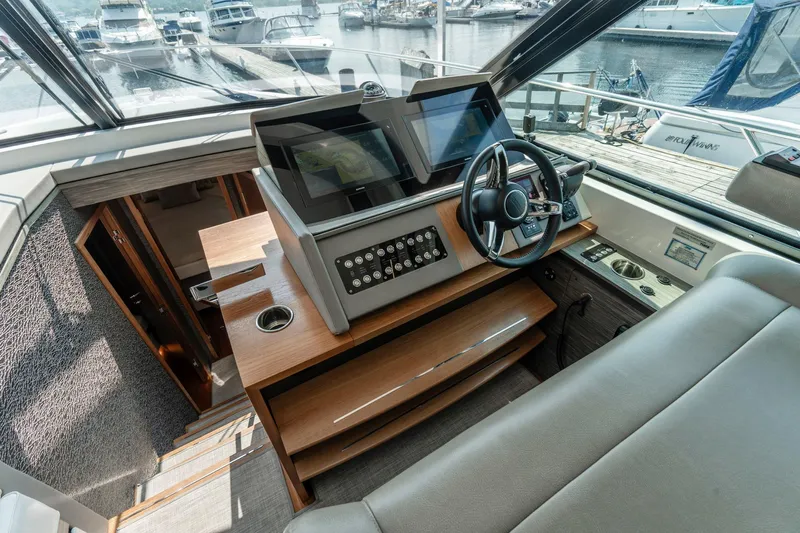  Yacht Photos Pics 2019 Tiara Yachts C49 Coupe helm with modern controls and steering wheel, docked at marina.