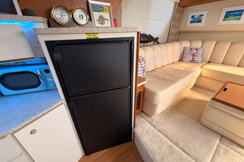  Yacht Photos Pics 1998 Silverton 40 Convertible interior with beige seating, black fridge, and blue microwave.