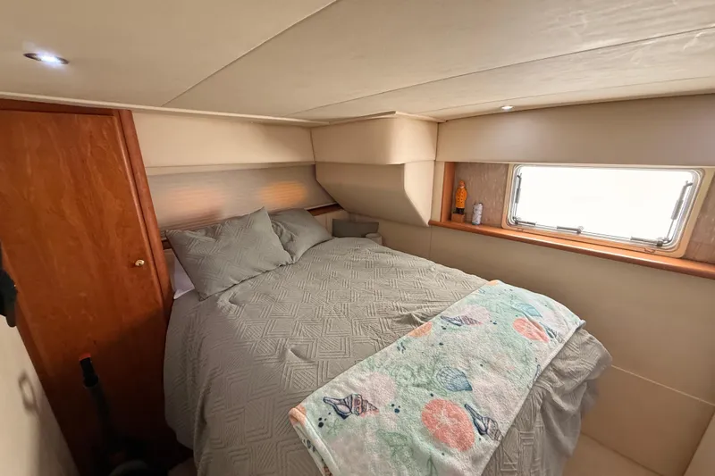  Yacht Photos Pics Cozy bedroom interior of 1998 Silverton 40 Convertible yacht with window and wooden accents.