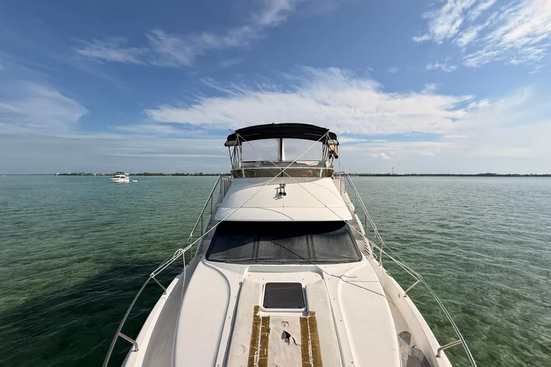  Yacht Photos Pics 1998 Silverton 40 Convertible yacht on calm waters under a clear blue sky.