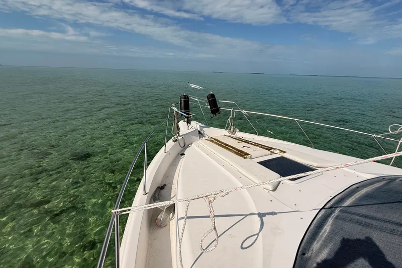  Yacht Photos Pics 1998 Silverton 40 Convertible boat cruising on clear turquoise waters under a blue sky.