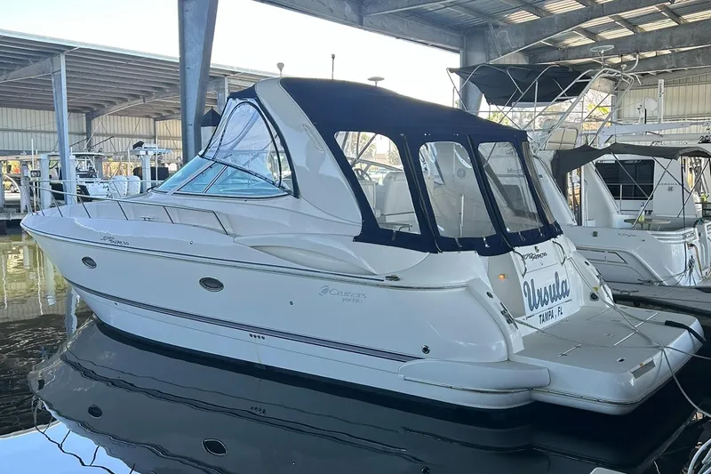 Ursula Yacht Photos Pics 2006 Cruisers Yachts 370 Express docked in a marina, featuring a sleek white design and blue canopy.