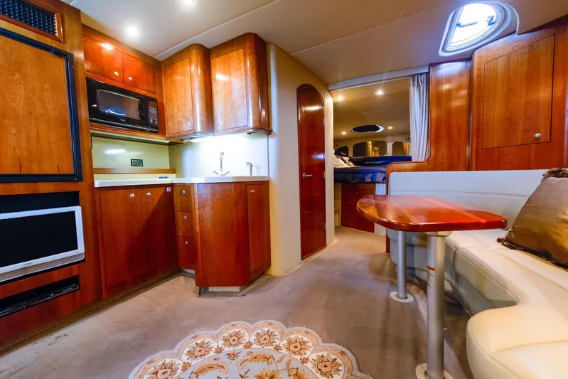 Ursula Yacht Photos Pics Luxurious 2006 Cruisers Yachts 370 Express interior with wood cabinetry and cozy seating area.
