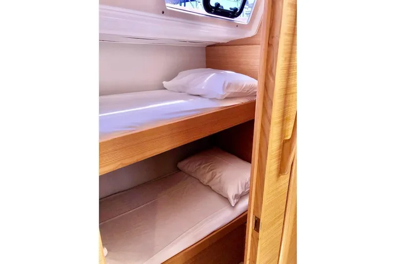  Yacht Photos Pics Bunk beds in 2020 Dufour 430 yacht cabin, featuring wooden interior and cozy bedding.