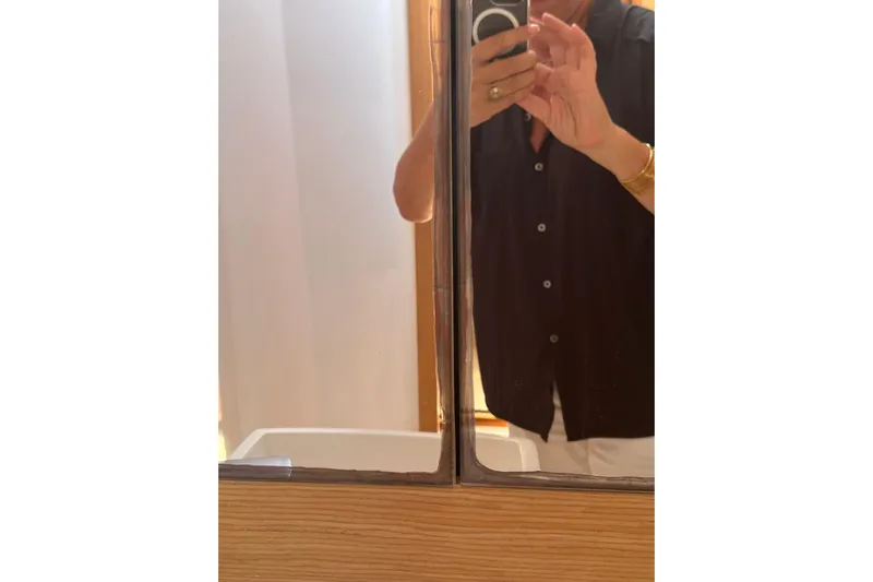  Yacht Photos Pics Person taking a mirror selfie inside a 2020 Dufour 430 yacht bathroom.