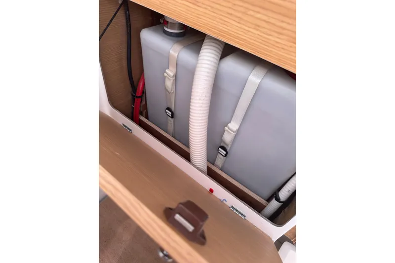  Yacht Photos Pics Storage compartment in a 2020 Dufour 430 yacht, featuring secured tanks and hoses.