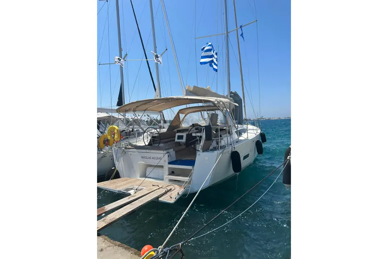  Yacht Photos Pics 2020 Dufour 430 sailboat docked, featuring a Greek flag and clear blue skies.