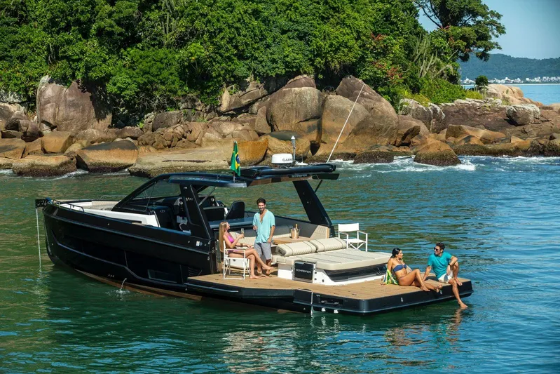  Yacht Photos Pics 2026 Schaefer V44 yacht with people relaxing near a scenic rocky shoreline.