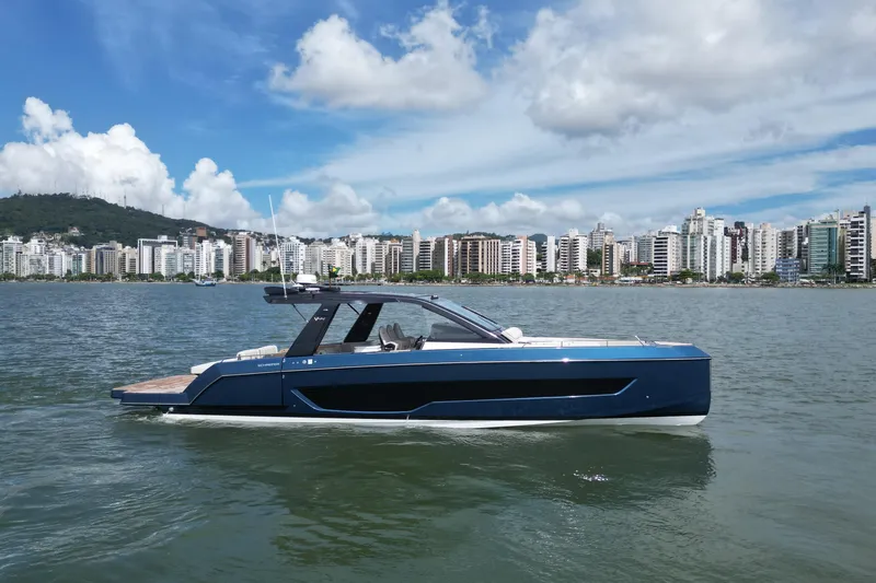  Yacht Photos Pics 2026 Schaefer V44 yacht cruising near urban skyline under blue skies.