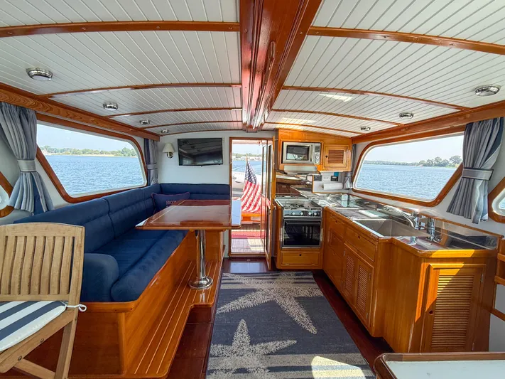 Argonaut Yacht Photos Pics Luxurious interior of a 1984 Wilbur 38 yacht with elegant wood finishes and scenic water views.