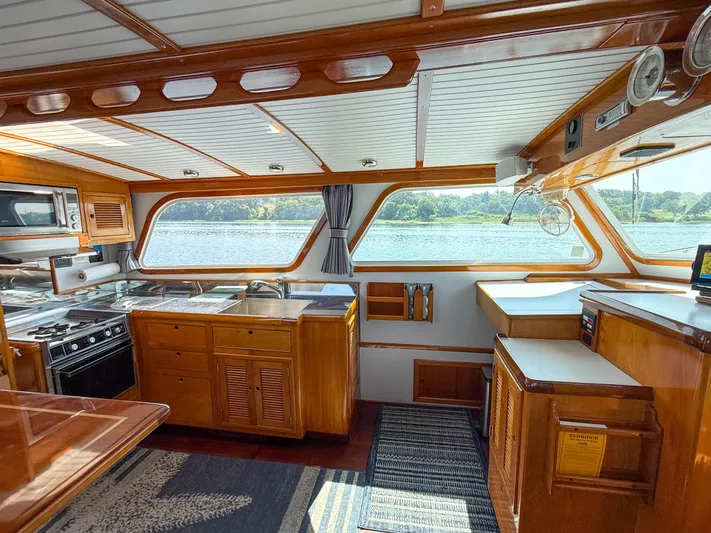 Argonaut Yacht Photos Pics Interior of 1984 Wilbur 38 boat with wooden cabinetry and scenic water view.