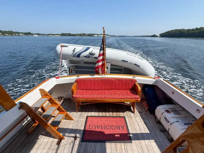 Argonaut Yacht Photos Pics Vintage 1984 Wilbur 38 boat deck with red seating, American flag, and inflatable dinghy.