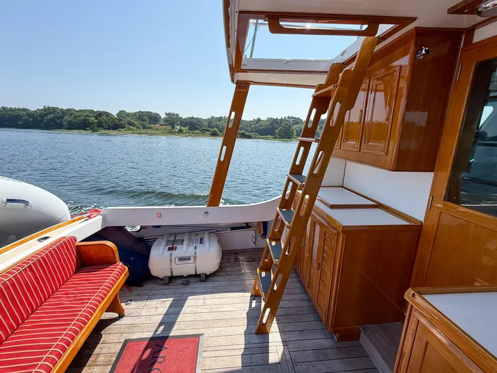 Argonaut Yacht Photos Pics Interior of 1984 Wilbur 38 boat with wooden cabinetry and outdoor seating.