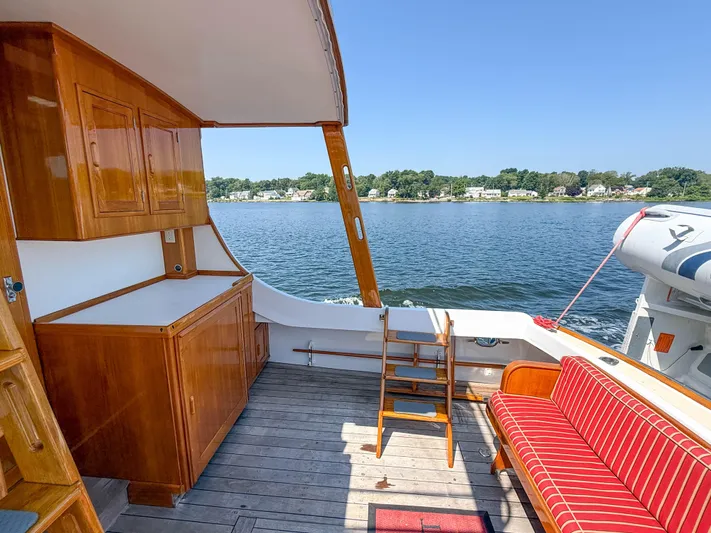 Argonaut Yacht Photos Pics 1984 Wilbur 38 boat interior with wooden cabinetry, striped seating, and scenic water view.