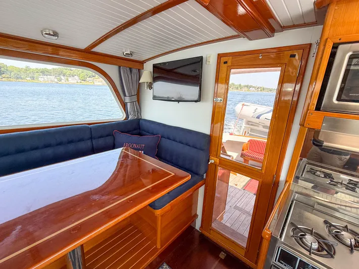 Argonaut Yacht Photos Pics Interior of 1984 Wilbur 38 boat with dining area, stove, and scenic water view.