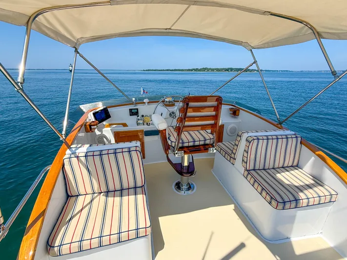 Argonaut Yacht Photos Pics Cockpit of 1984 Wilbur 38 boat with striped seating, overlooking calm blue waters.