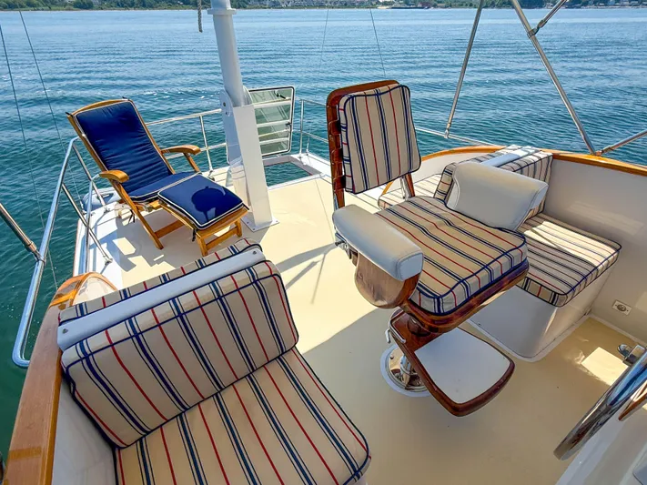Argonaut Yacht Photos Pics Luxury seating on 1984 Wilbur 38 yacht deck with striped cushions, overlooking serene water.