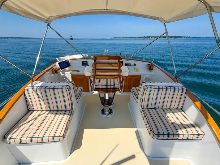 Argonaut Yacht Photos Pics 1984 Wilbur 38 boat interior with striped seating, overlooking calm blue waters.