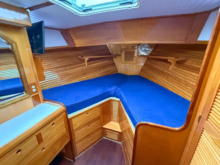 Argonaut Yacht Photos Pics Cozy cabin interior of 1984 Wilbur 38 boat with blue bedding and wooden finish.