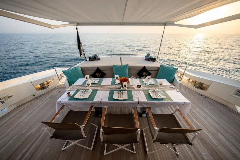  Yacht Photos Pics Luxury dining setup on 2016 Numarine 105HT yacht with ocean view at sunset.