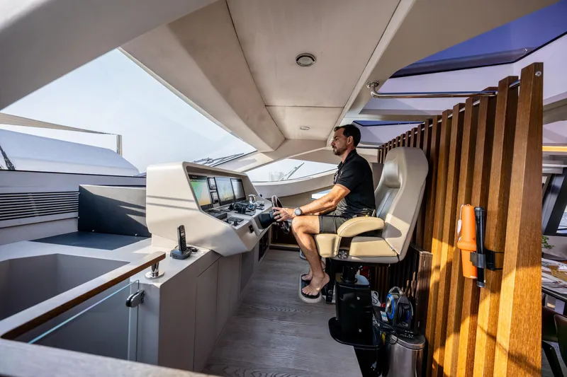  Yacht Photos Pics Man operating the helm of a 2016 Numarine 105HT yacht.
