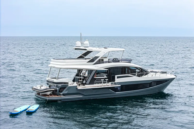  Yacht Photos Pics 2023 Galeon 640 Fly yacht on open sea with paddleboards nearby.