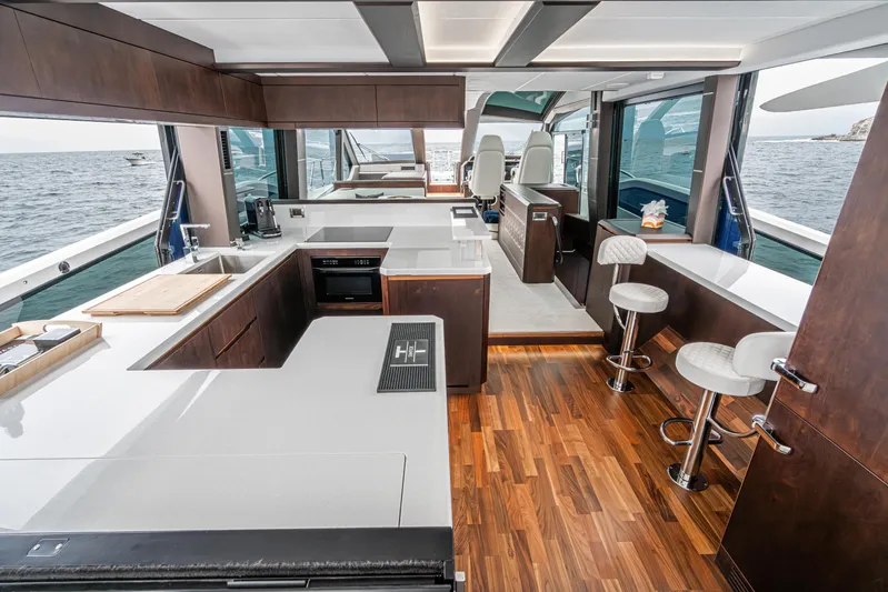  Yacht Photos Pics Luxurious interior of 2023 Galeon 640 Fly yacht with modern kitchen and seating area.