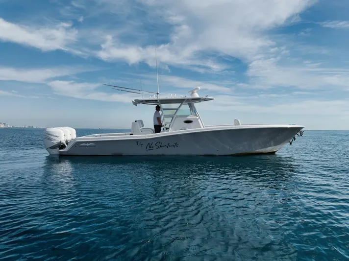 T/t No Shortcuts Yacht Photos Pics 2020 Invincible Open Fisherman boat on calm ocean waters under a blue sky.