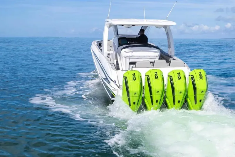  Yacht Photos Pics 2026 Deep Impact 399 Sport boat with four green outboard motors cruising on open water.
