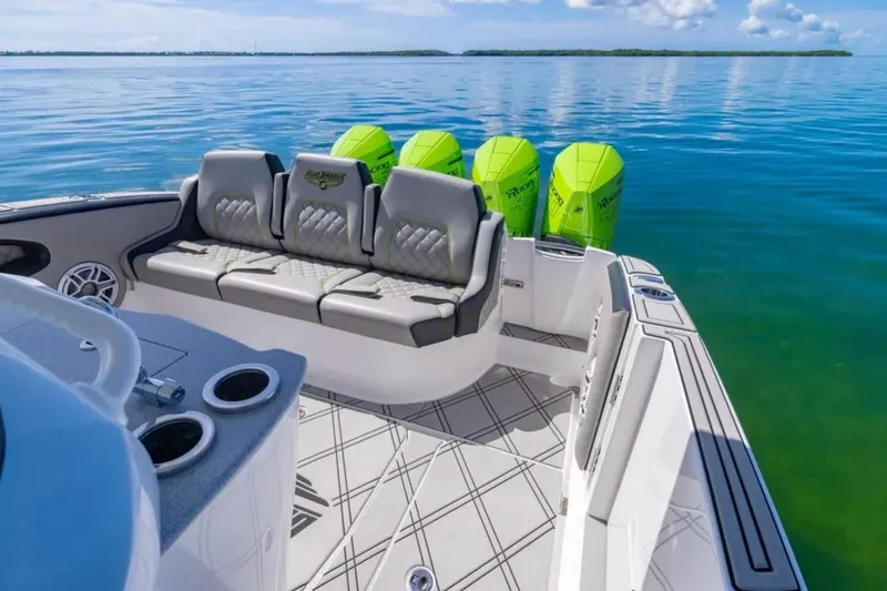  Yacht Photos Pics 2026 Deep Impact 399 Sport boat with luxurious seating and vibrant green engines on calm water.