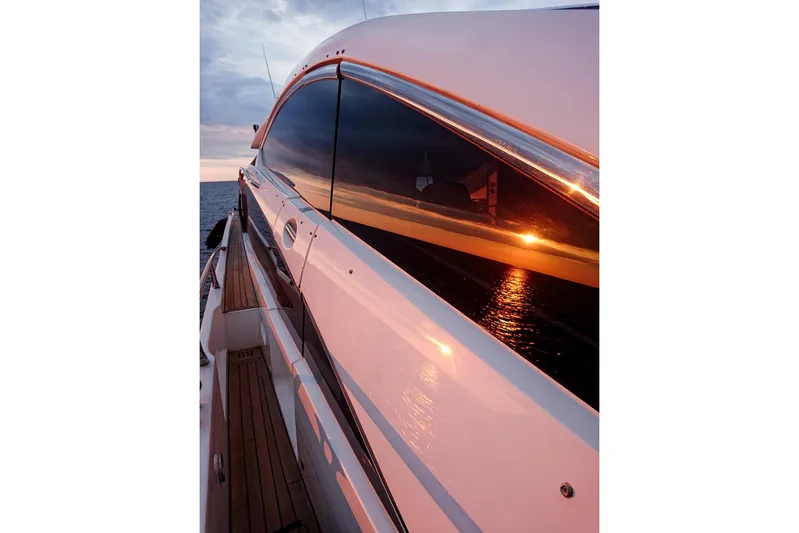 Black Zen Yacht Photos Pics 2006 Sunseeker Predator 82 yacht reflecting sunset on ocean.