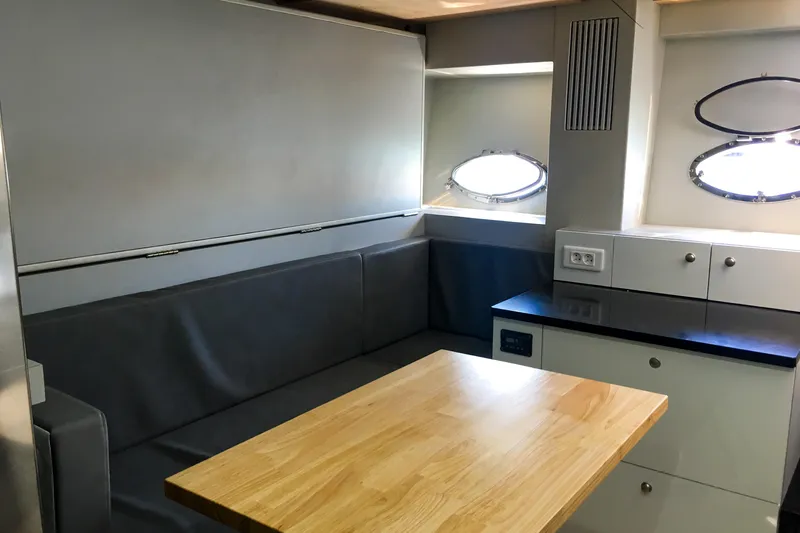 Black Zen Yacht Photos Pics Interior of 2006 Sunseeker Predator 82 yacht with modern seating and wooden table.