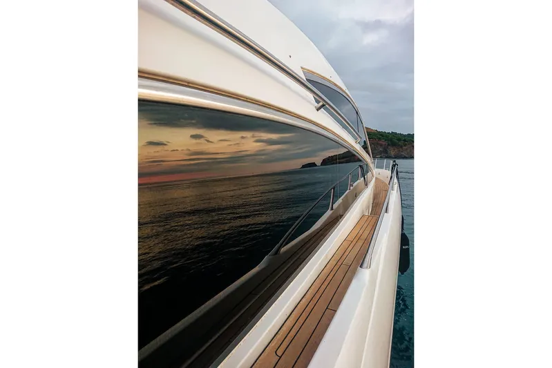 Black Zen Yacht Photos Pics 2006 Sunseeker Predator 82 yacht reflecting sunset on calm sea.