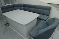 Cozy seating area on 2007 Custom VSV boat with gray cushions and table.
