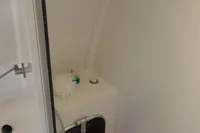 Compact shower area in a 2007 Custom VSV model with orange seat and modern fixtures.