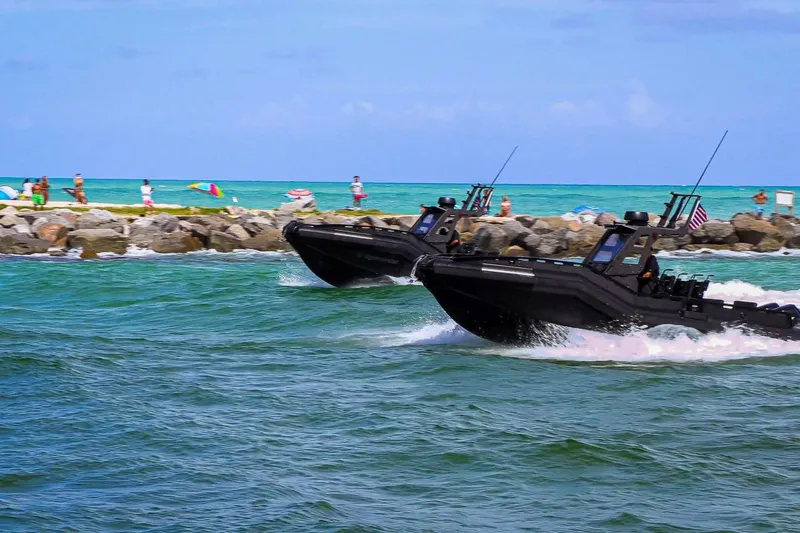  Yacht Photos Pics Two DGS 777 military boats speeding near a rocky shoreline, 2022 model.