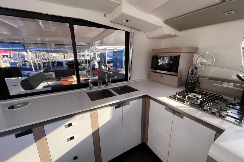 Zensation Yacht Photos Pics Modern kitchen interior of 2023 Fountaine Pajot Tanna 47 catamaran, featuring sleek countertops and appliances.