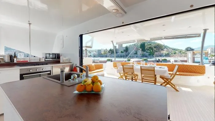 Ti Marin Yacht Photos Pics Luxurious 2020 O Yachts Class 6 interior with kitchen and dining area, overlooking scenic waterfront.