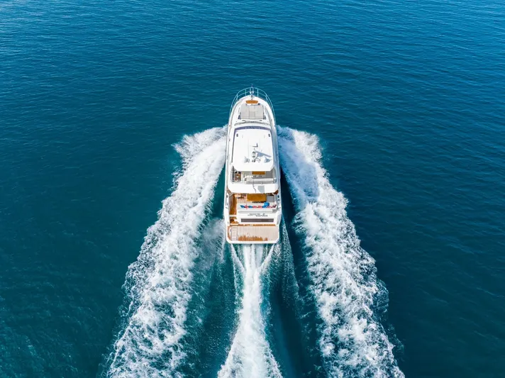  Yacht Photos Pics Aerial view of 2020 Prestige 590 Flybridge Cruiser navigating open blue waters.