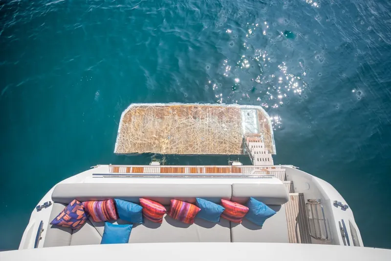  Yacht Photos Pics Luxurious 2020 Prestige 590 Flybridge Cruiser with colorful cushions, overlooking sparkling blue water.